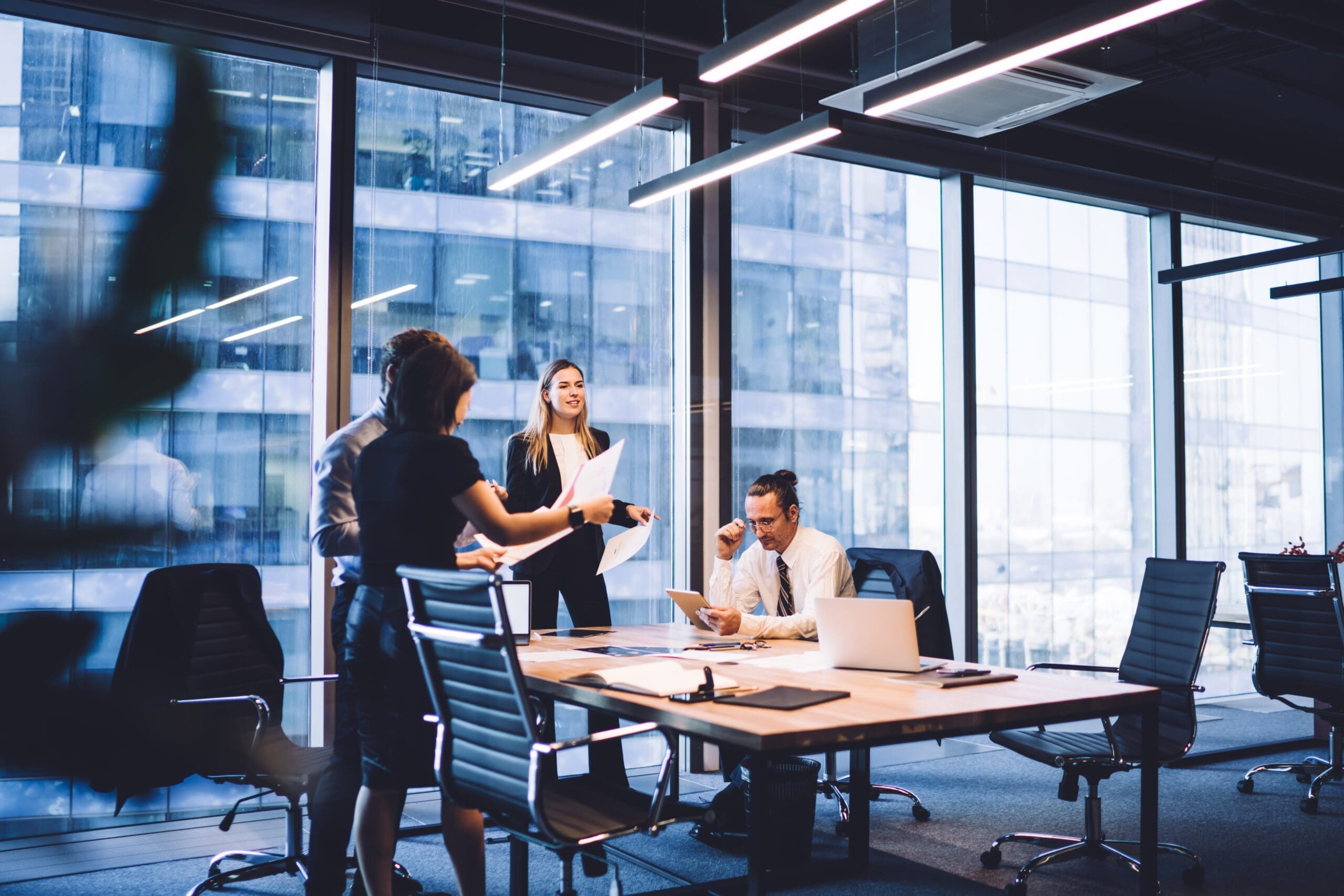 Cooperation process of professional male and female partners, successful corporate colleagues analyzing information from paper documents during working time in conference room with desktop
